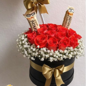 Arreglo en base con flores anaranjadas con chocolates
