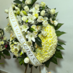 Corona funebre de rosas blancas y lirios