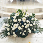 Caja base funebre de gerberas y rosas blancas mas lirios follaje