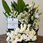 Caja base fúnebre de gerberas y rosas blancas mas lirios mas follaje